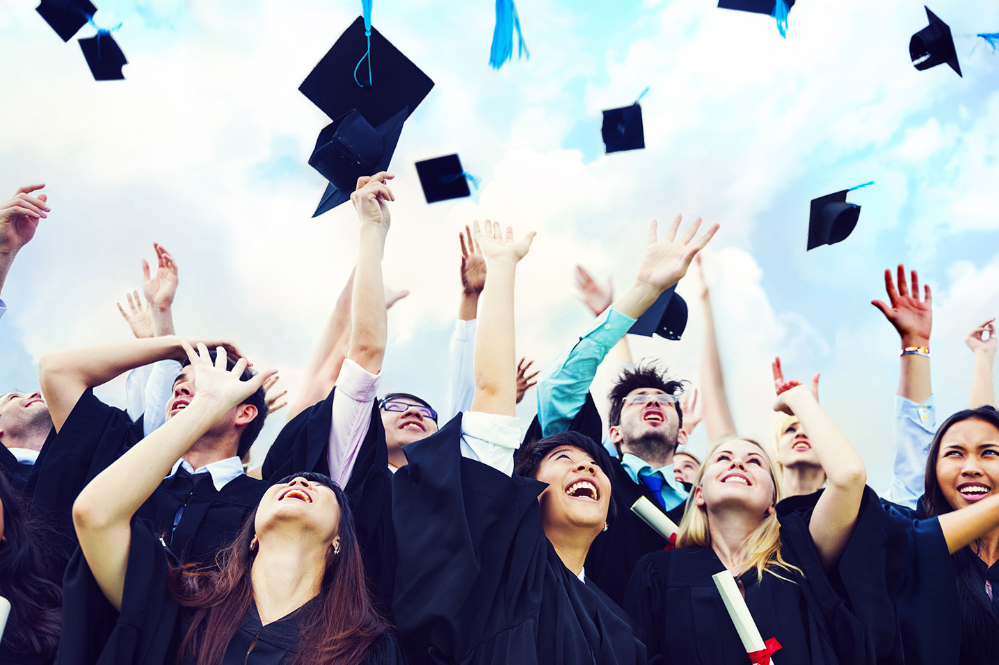 Students throw their mortarboards in the air